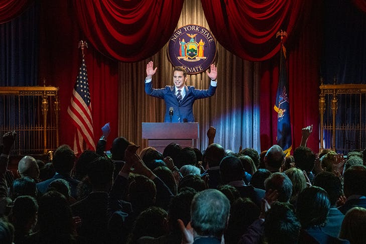 man standing at podium addressing room of people